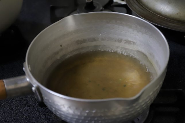 片手鍋で温めているラーメンのスープ