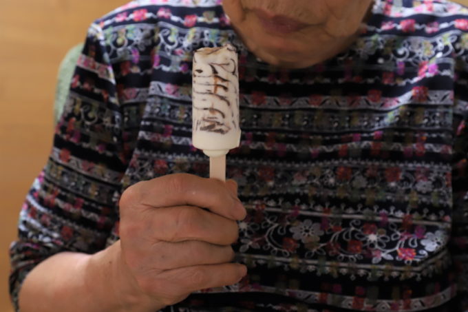 森永のアイス「パリパリバー」（バニラアイスにチョコがマーブル状に混ざっている）を手にしている祖母（おばあ）