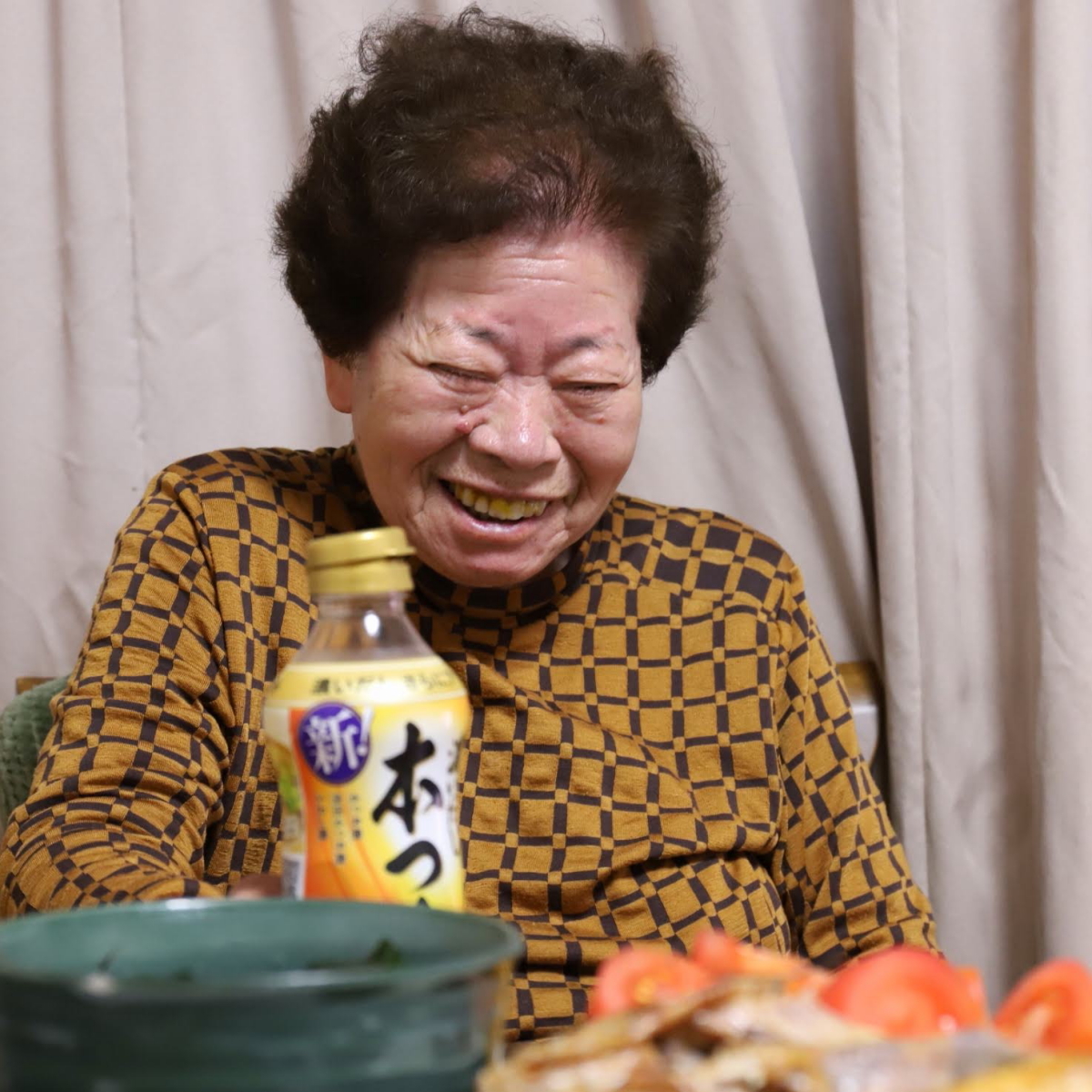 食卓に着いて笑っている祖母（おばあ）