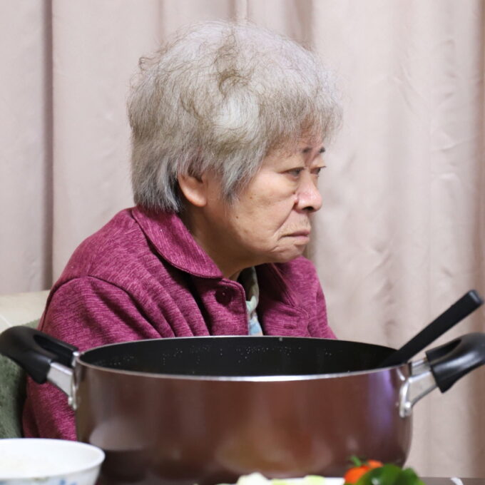 食卓に着いてテレビを観ている祖母・おばあ