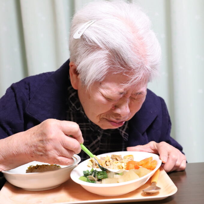 大根の煮物を食べる祖母