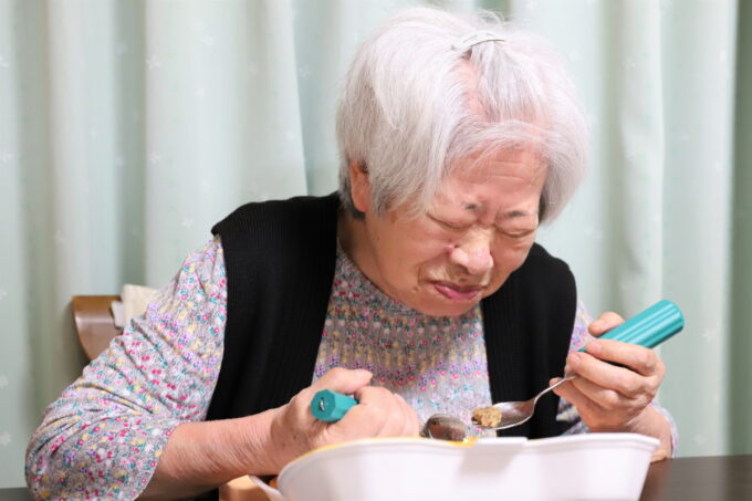 晩ごはんを食べる高齢の祖母