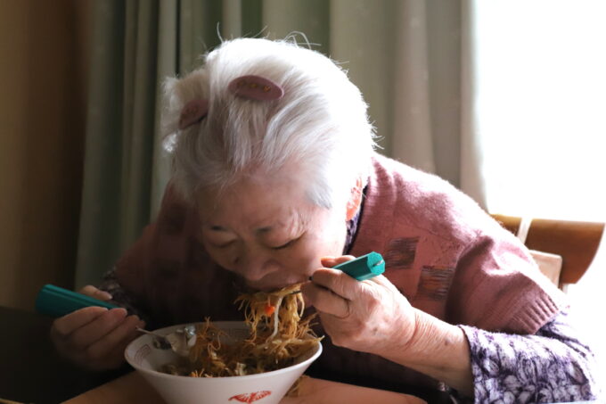 皿うどんをすごい勢いで食べる祖母（おばあ）