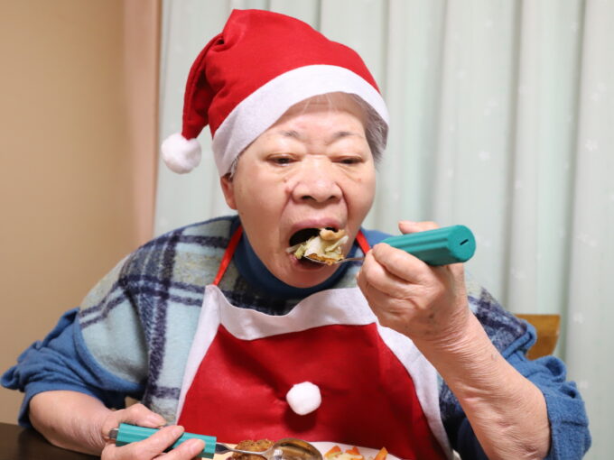 クリスマスチキンをスプーンで食べる祖母