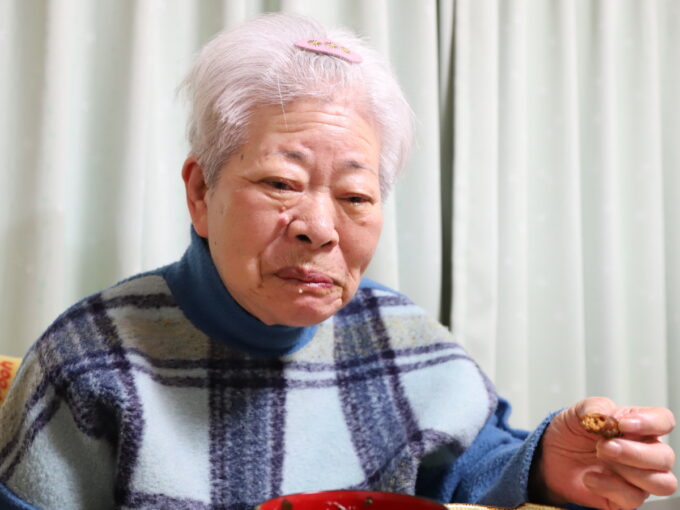 かりんとうを食べて笑顔の祖母（おばあ）