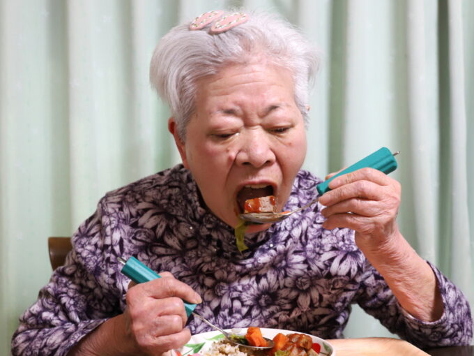 ハンバーグをユニバーサルスプーンですくって食べる祖母