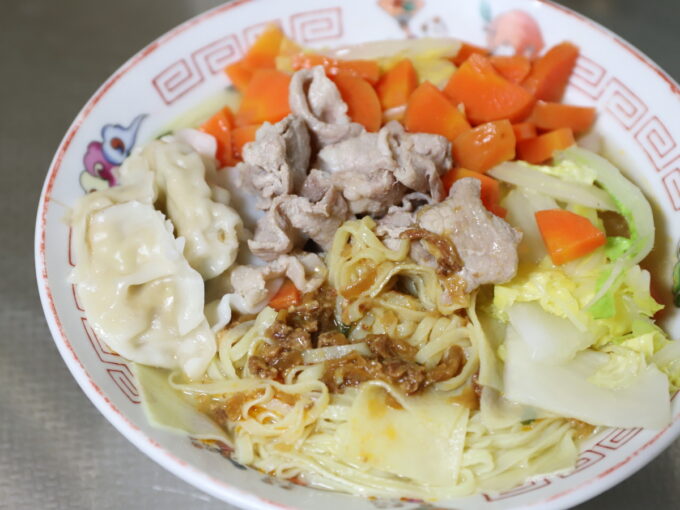 ベトナムのインスタント麵に餃子や豚肉、ニンジン、白菜などの具材をトッピングしたもの