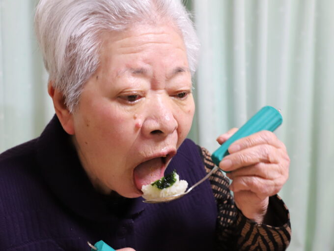 青のりの佃煮のおにぎりをスプーンで食べるおばあちゃん（おばあ）