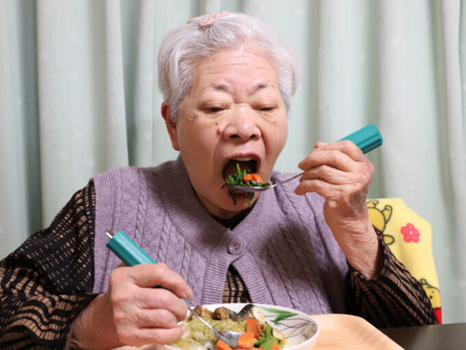 介護用スプーンを使って食事中の祖母