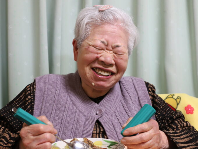 ごはんを食べて笑顔の祖母