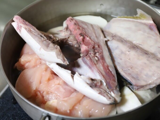 ステンレスの鍋に大根と鶏肉とブリを入れ、煮物にするために煮るところ
