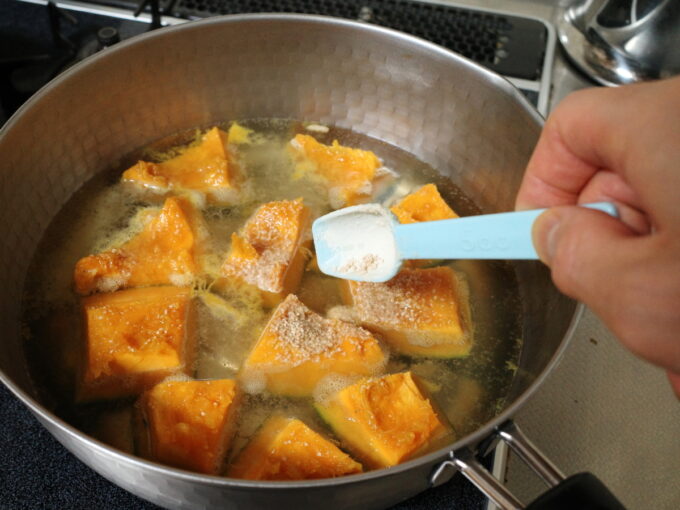 鍋に砂糖を入れて、かぼちゃの煮物を作っているところ