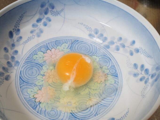 電子レンジで温泉卵を作るため、生卵を水の入った容器に入れている
