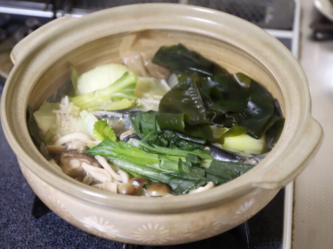 土鍋で煮て湯気が上がっている海藻や野菜