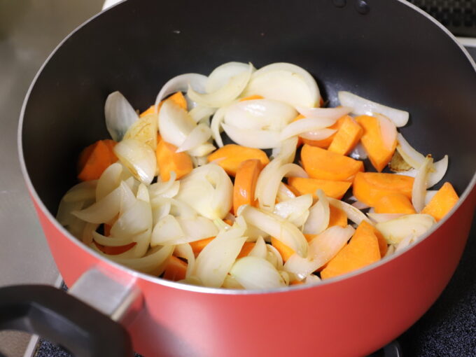 カレーを作るために玉ねぎとニンジンを鍋で炒めているところ