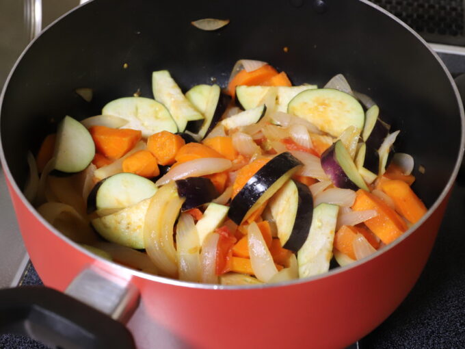 玉ねぎとニンジン、トマト、茄子を炒めてカレーを作っているところ