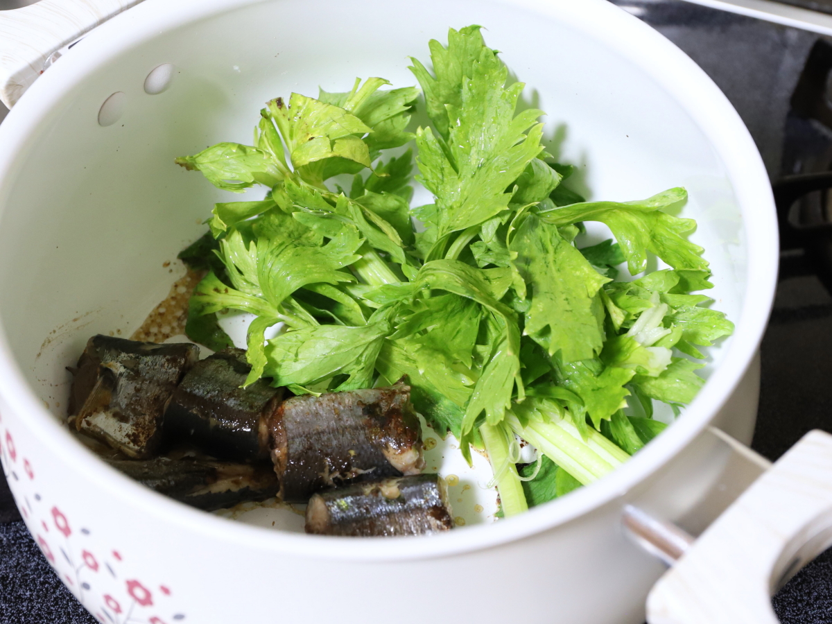 鍋に魚と野菜を入れて炒め、パスタのソースを作っている