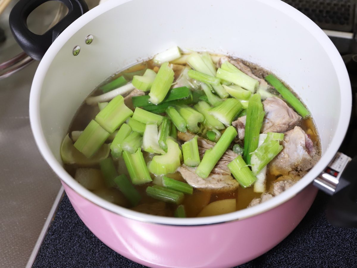 鍋に肉と香味野菜、セロリを入れて煮込んでいる