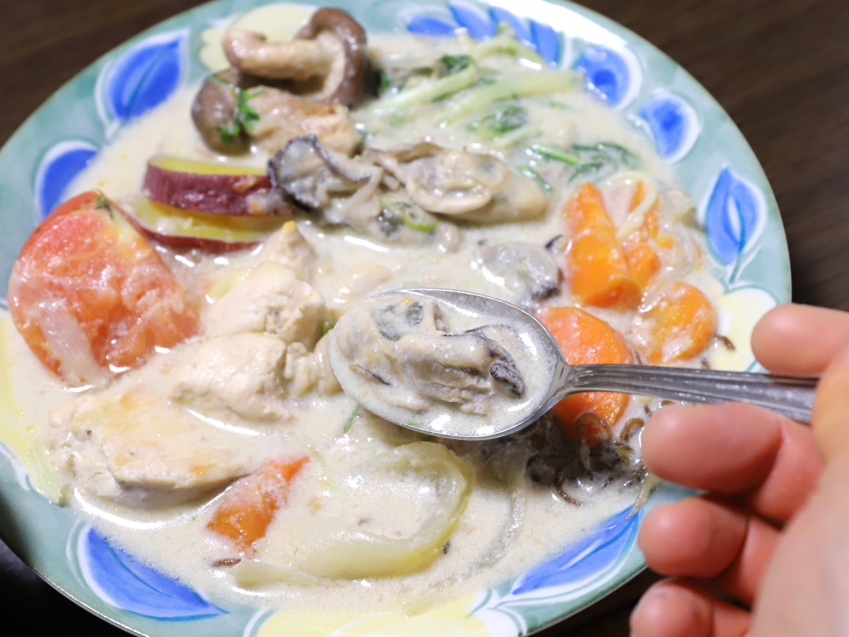 シチューに入れた牡蠣をスプーンですくっている