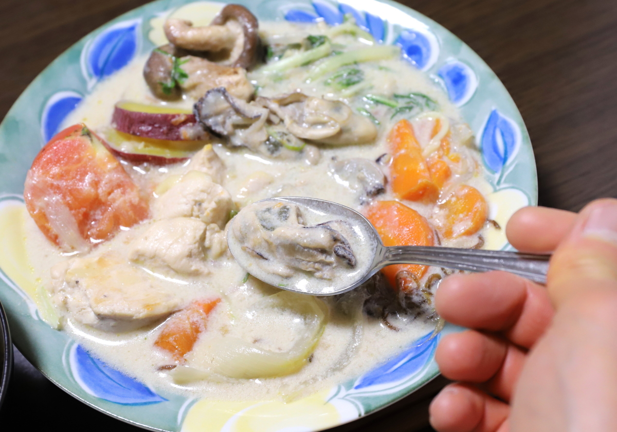 シチューに入れた牡蠣をスプーンですくっている