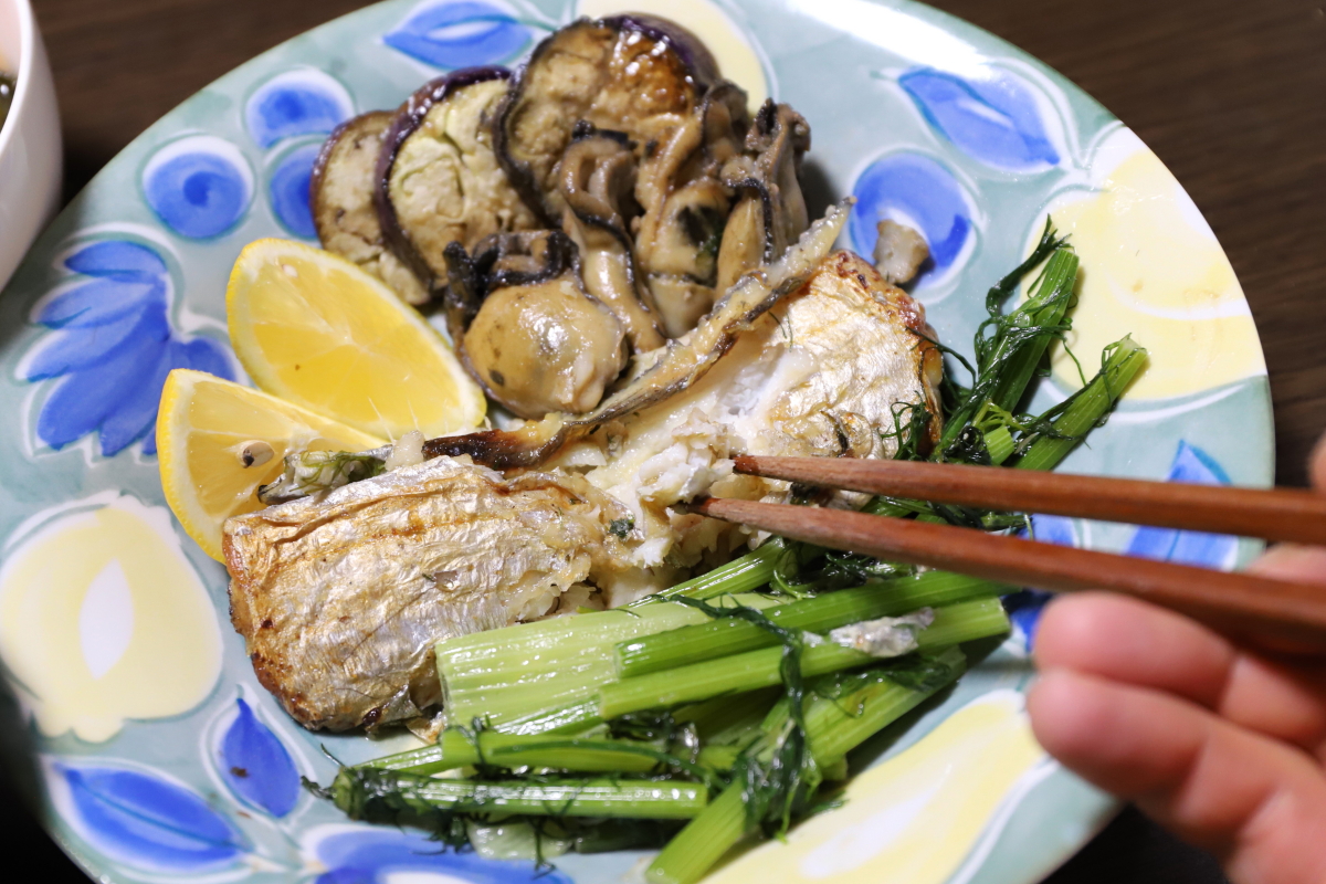 太刀魚のバター焼きを箸でつまんで食べようとしているところ