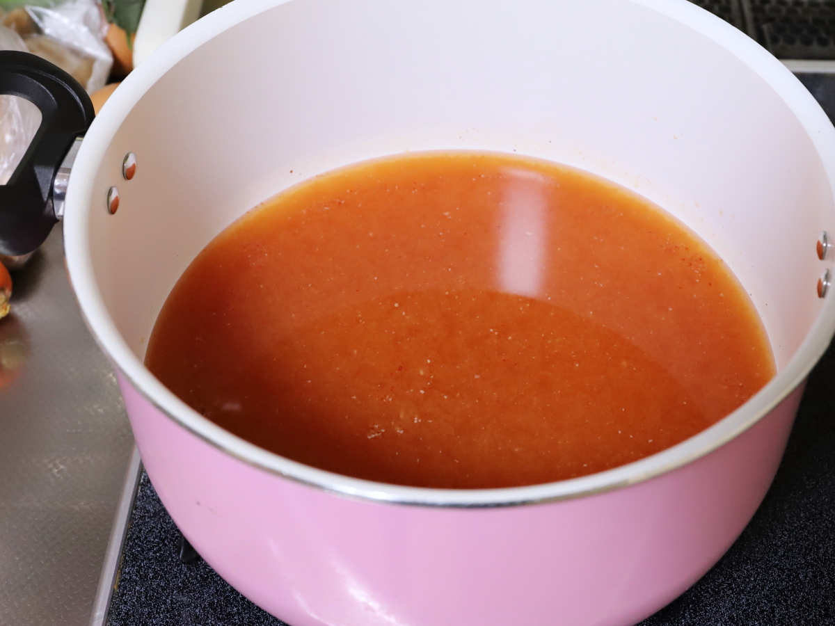 桃屋キムチの素とケチャップを入れた鍋を火にかけ、晩ごはんの支度をしている
