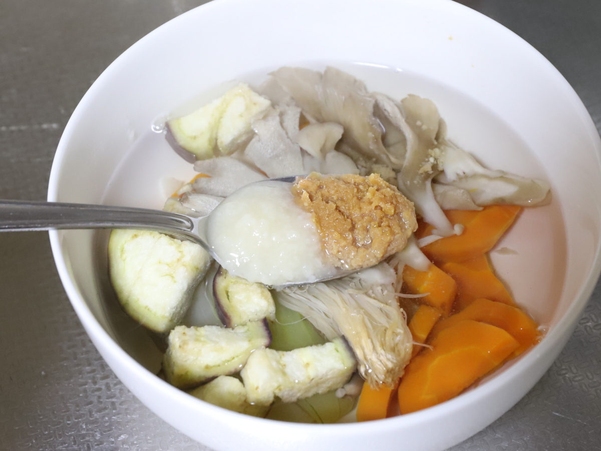 レンチンした野菜にお湯をそそぎ味噌と塩麴を溶かして味噌汁を作っている